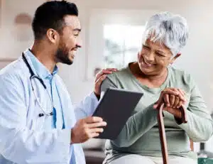 Elderly woman and her doctor smiling, looking at a report